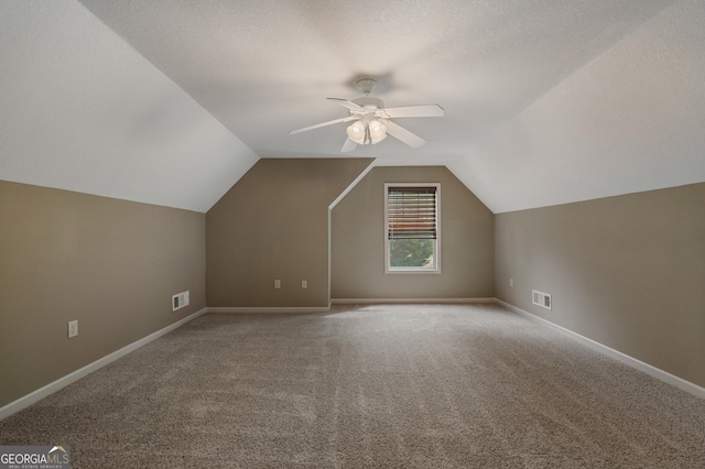 additional living space featuring carpet floors, lofted ceiling, visible vents, and a ceiling fan