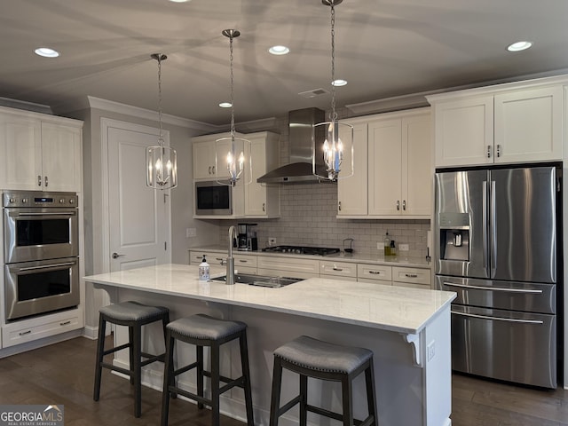 kitchen featuring ornamental molding, an inviting chandelier, a sink, wall chimney exhaust hood, and appliances with stainless steel finishes