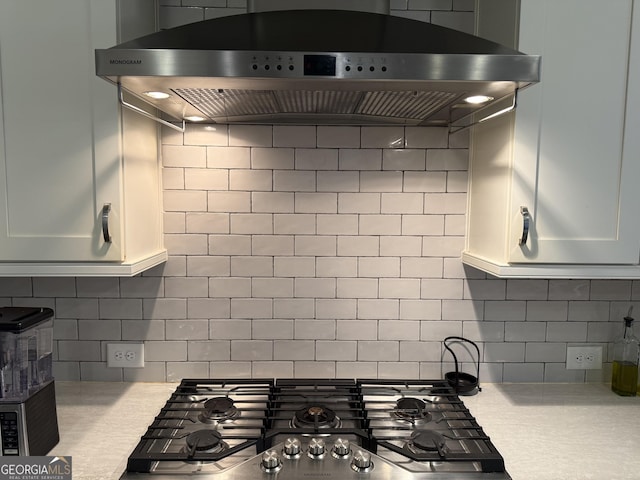 kitchen with backsplash, light countertops, ventilation hood, and stainless steel gas stovetop