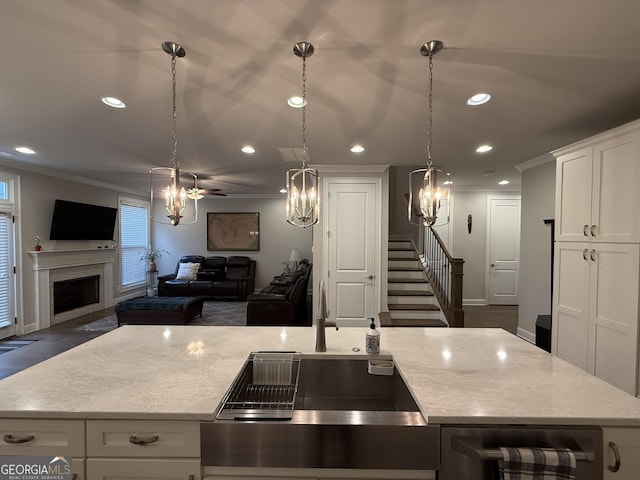 kitchen featuring a sink, recessed lighting, a chandelier, crown molding, and open floor plan