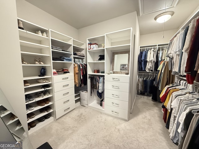 spacious closet with light carpet and attic access