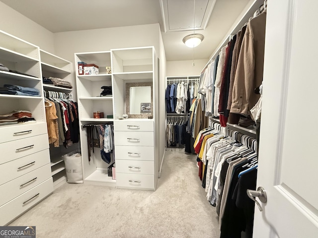 spacious closet with light carpet and attic access