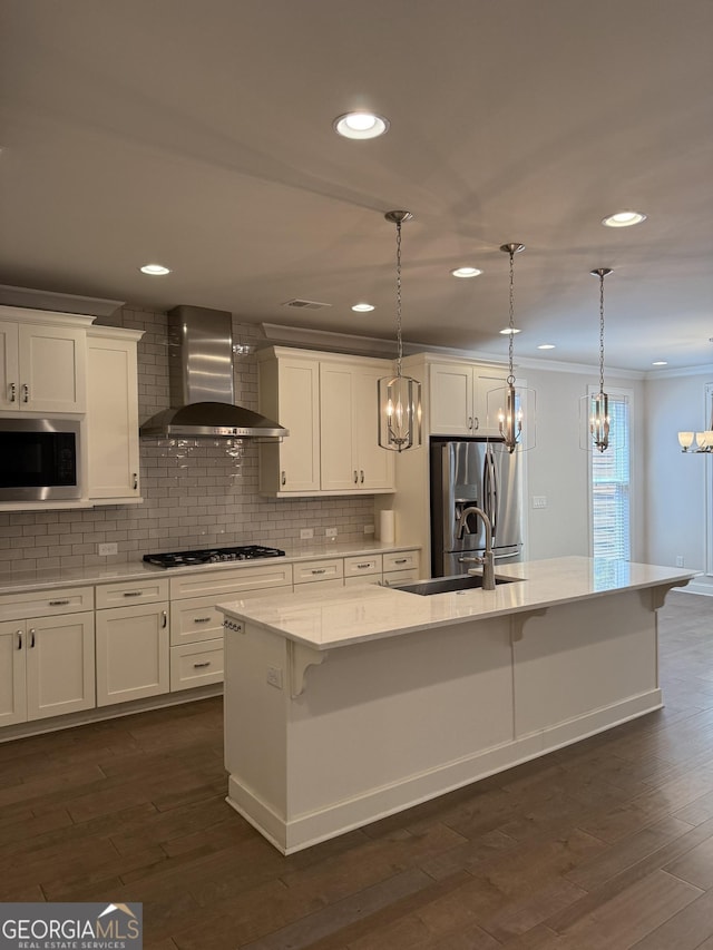 kitchen with wall chimney range hood, stainless steel appliances, tasteful backsplash, and an inviting chandelier