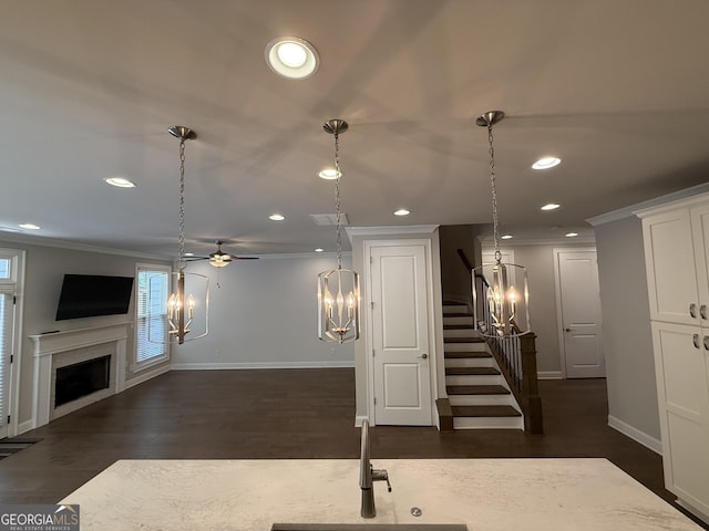 interior space with recessed lighting, a fireplace, dark wood-style floors, white cabinets, and baseboards