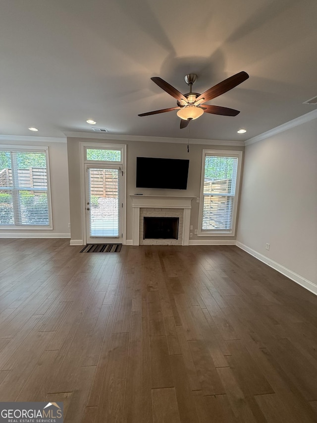 unfurnished living room with a fireplace, baseboards, and ornamental molding