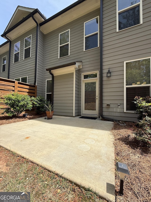 rear view of property featuring a patio and fence