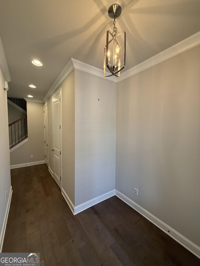 unfurnished dining area featuring recessed lighting, an inviting chandelier, crown molding, and dark wood-style floors
