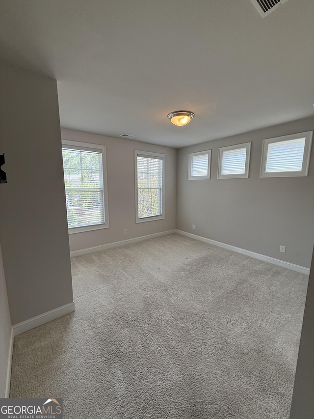 carpeted empty room with baseboards and visible vents