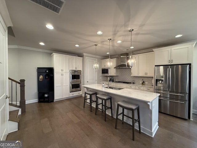 kitchen featuring wall chimney range hood, recessed lighting, and appliances with stainless steel finishes
