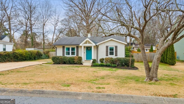 view of front of home with a front yard, brick siding, and fence