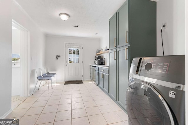 kitchen with ornamental molding, washer / clothes dryer, light countertops, and light tile patterned flooring