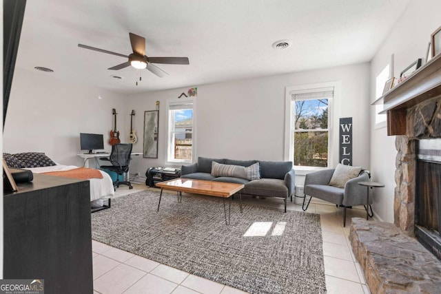 living room with a healthy amount of sunlight, light tile patterned floors, a fireplace, and visible vents