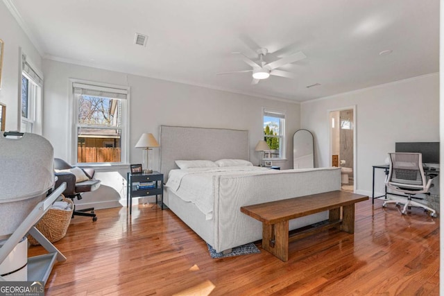 bedroom with light wood-style floors, multiple windows, crown molding, and baseboards