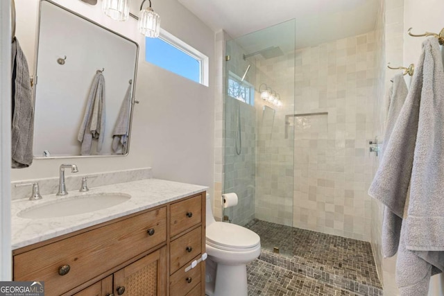 full bathroom featuring a walk in shower, vanity, and toilet