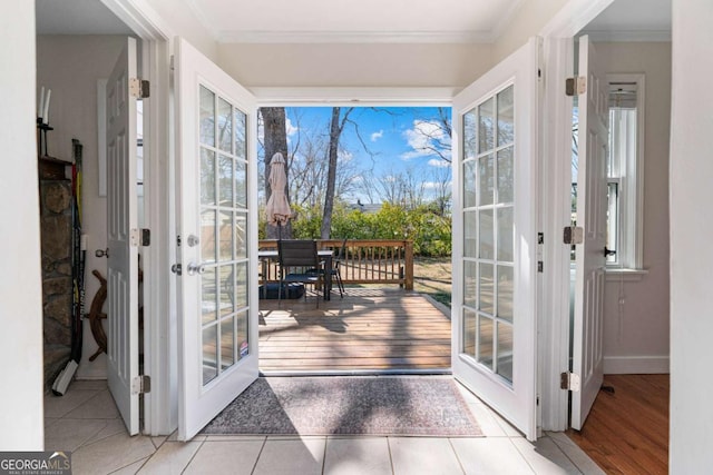 doorway with baseboards, french doors, wood finished floors, and crown molding