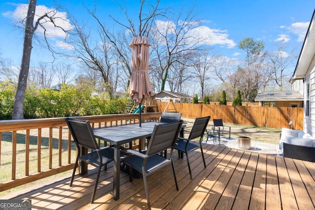 wooden terrace with an outdoor fire pit, outdoor dining area, and fence