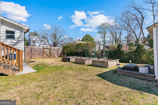 view of yard featuring a gate, a vegetable garden, and fence