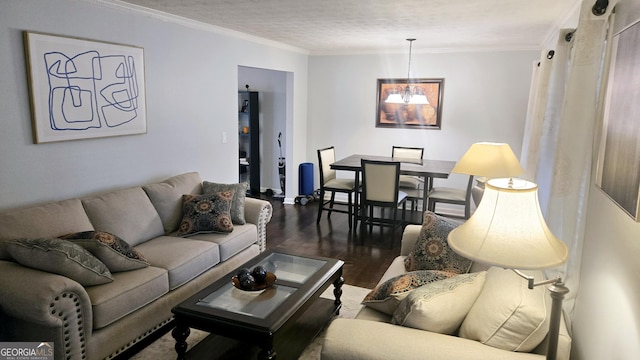 living area featuring crown molding, a textured ceiling, an inviting chandelier, and wood finished floors