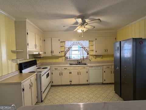 kitchen featuring white appliances, under cabinet range hood, light floors, and a sink