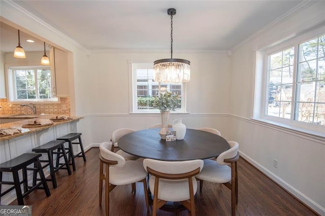 dining room featuring an inviting chandelier, crown molding, baseboards, and dark wood-type flooring