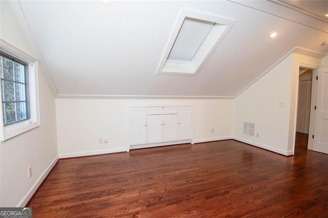 bonus room featuring lofted ceiling with skylight, baseboards, visible vents, and dark wood finished floors