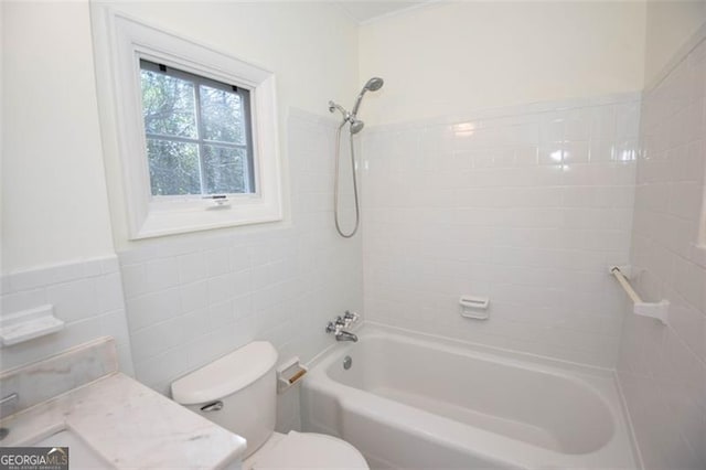 full bath featuring shower / bathing tub combination, vanity, toilet, and tile walls