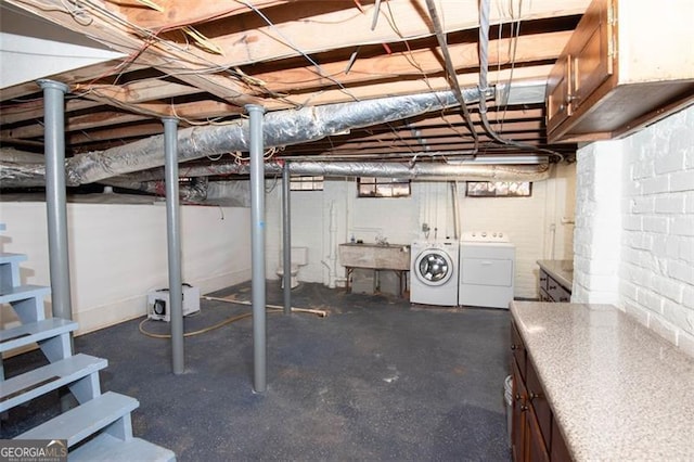 unfinished below grade area featuring washing machine and dryer and a sink