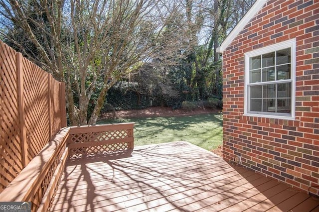 deck with a lawn and fence