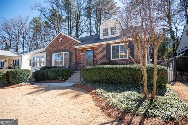 view of front of property featuring fence and brick siding