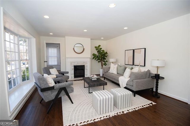 living room featuring a premium fireplace, recessed lighting, wood finished floors, and baseboards