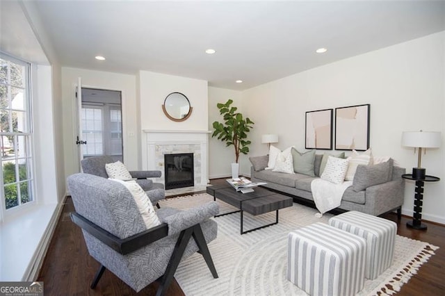 living area with a healthy amount of sunlight, recessed lighting, wood finished floors, and a high end fireplace