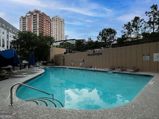 community pool featuring a patio area and fence