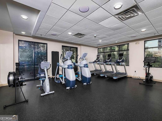 workout area featuring baseboards, visible vents, and a drop ceiling