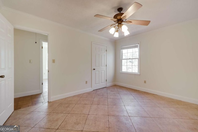 spare room with light tile patterned floors, ornamental molding, a ceiling fan, and baseboards