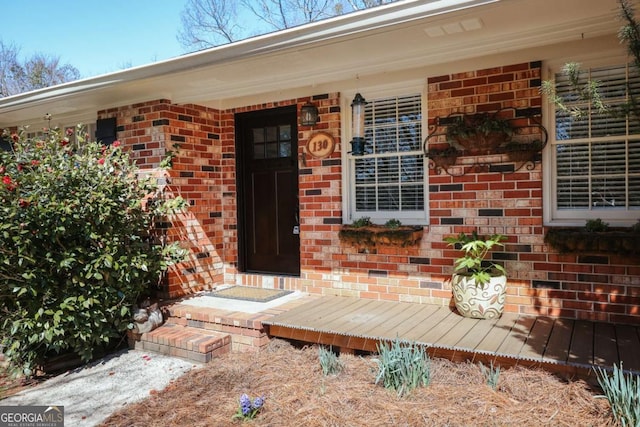 view of exterior entry with brick siding