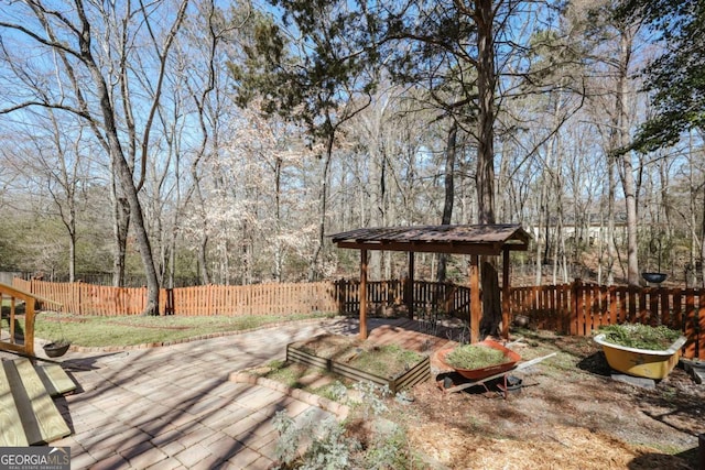 wooden deck featuring a gazebo, a forest view, and fence