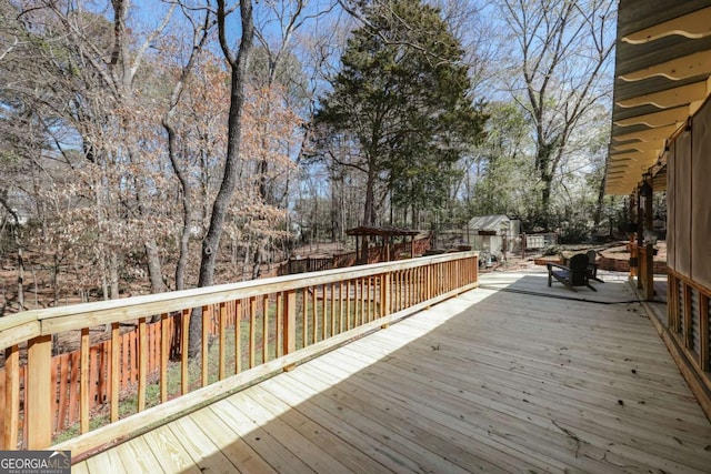 wooden deck featuring an outdoor structure and a shed