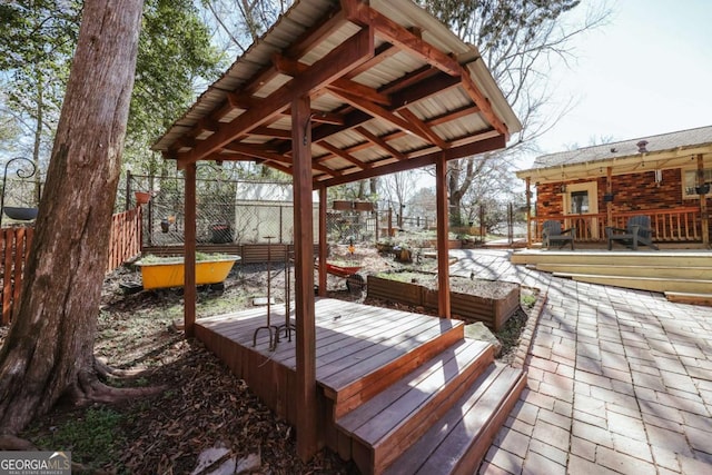 wooden terrace featuring a patio area and fence