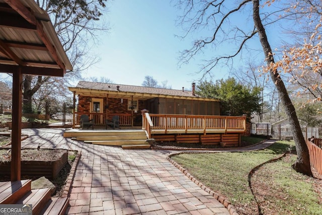 rear view of property featuring a deck and fence