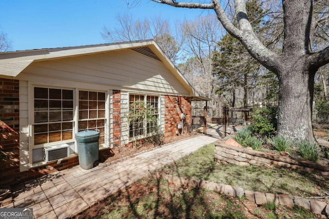 exterior space with brick siding and fence