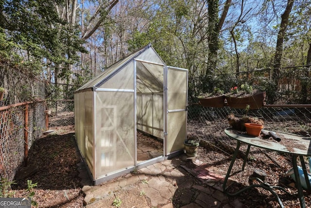 view of greenhouse featuring a fenced backyard