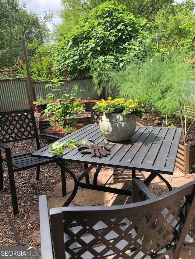 view of patio with a vegetable garden and fence