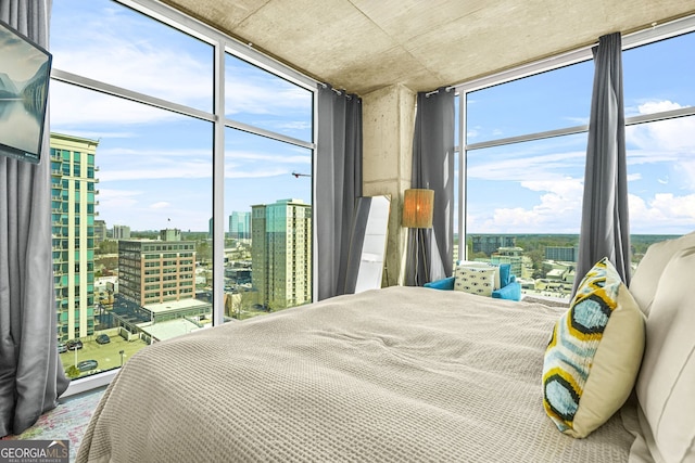 bedroom featuring access to outside, a view of city, and expansive windows