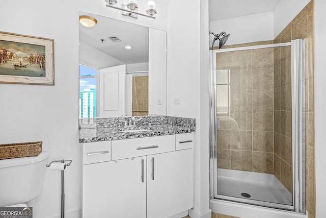 full bath featuring vanity, a shower stall, toilet, and visible vents