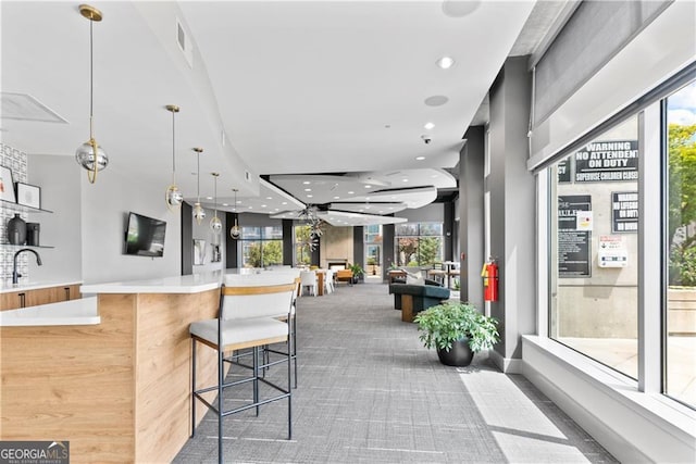 interior space with pendant lighting, a sink, recessed lighting, carpet flooring, and light countertops