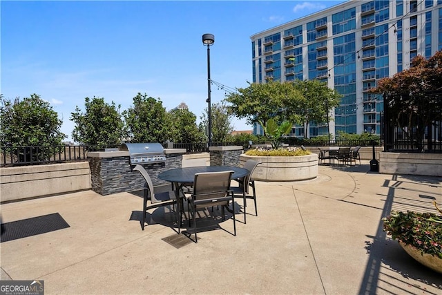 view of patio featuring an outdoor kitchen, outdoor dining area, and fence