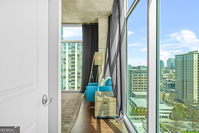 doorway to outside featuring a wall of windows, a view of city, and wood finished floors