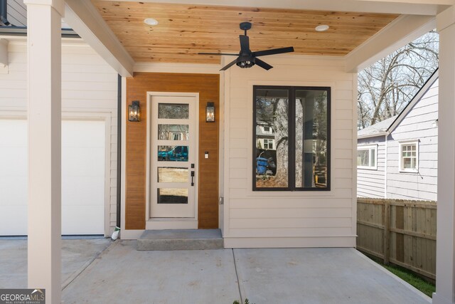 doorway to property with a ceiling fan and fence