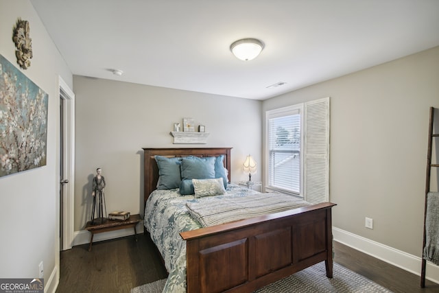 bedroom with dark wood-style flooring and baseboards