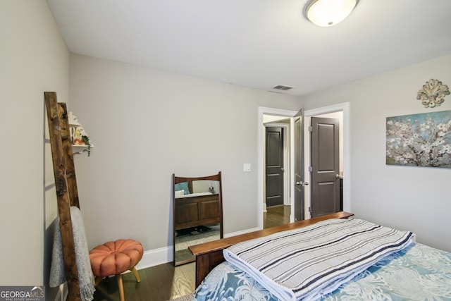 bedroom featuring visible vents, baseboards, and wood finished floors